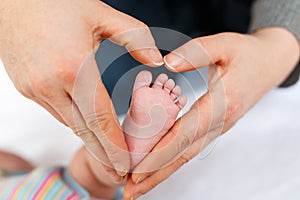 Father or mother holding foot of newborn baby