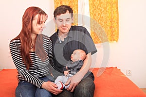 Father and mother holding newborn baby boy