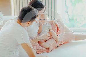 Father, mother and little son are relaxing on sofa in living room