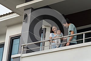 father and mother palying with infant baby at balcony of house. happy family