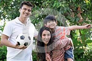 Father and mother playing with children outside.