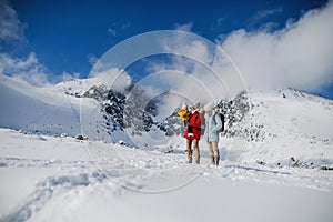 Otec a matka s malým synom v zimnej prírode, stojaci v snehu.