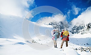 Father and mother with small son in winter nature, standing in the snow.