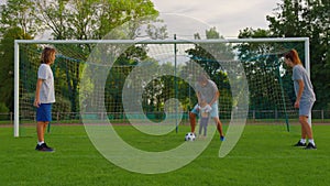 Father, mother, son and baby girl playing soccer for fun outdoors in park. Happy family. Parents and children play