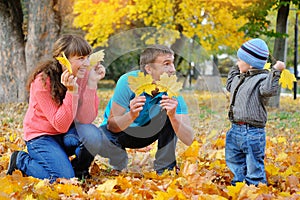 Father, mother and son happy family in autumn, yellow leaves