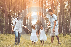 Father, mother and two little child girls holding hand