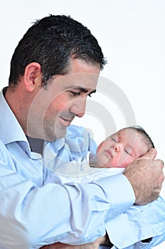 Father and newborn baby kissing and hugging.