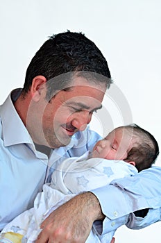 Father and newborn baby kissing and hugging.