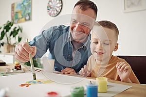 Father painting a picture with his son