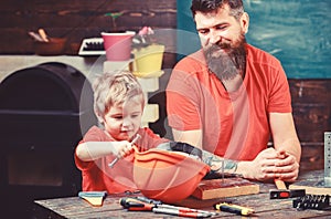 Father, parent with beard teaching little son to use different tools in school workshop. Fatherhood concept. Boy, child