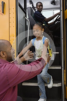 Father Picking Up Daughter At Bus Stop