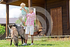 Father placing his son on nice little brown horse