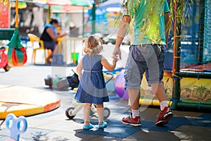 Little girl playing with her father on a playground. photo