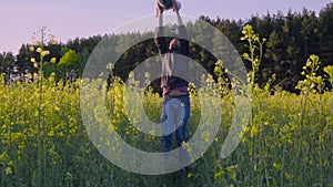 Father played with the baby in the rapeseed field and throws it Slow motion