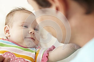 Father Playing With Baby Daughter At Home
