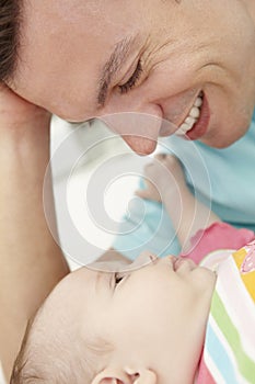 Father Playing With Baby Daughter At Home