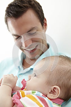 Father Playing With Baby Daughter At Home