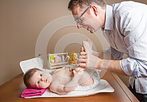 Father playing with baby feet after change diaper