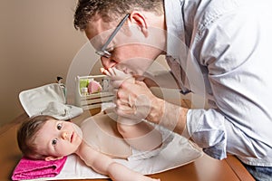 Father playing with baby feet after change diaper