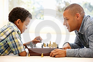 Father playing chess with son