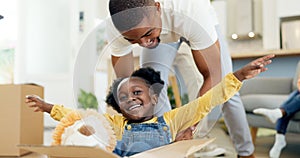 Father, playing and child in a box while moving house with a black family together in a living room. Man and a girl kid