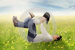 Father playing with daughter on meadow