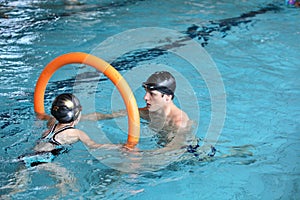 Father playing with daughter in swimming pool