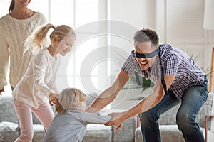 Father playing hide and seek game with kids at home