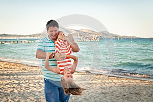 Father playing with his daughter on the evening beach