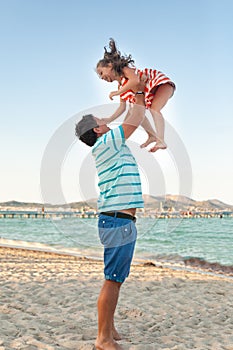 Father playing with his daughter on the evening beach