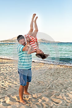 Father playing with his daughter on the evening beach