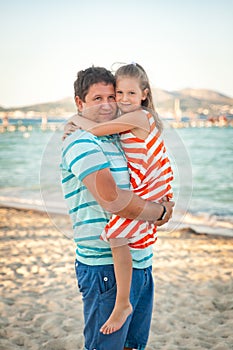 Father playing with his daughter on the evening beach