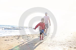 Father playing with his little daughter on sea beach