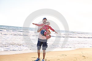 Father playing with his little daughter on sea beach