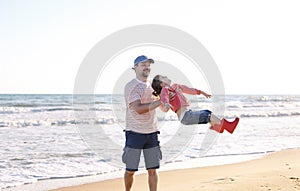 Father playing with his little daughter on sea beach