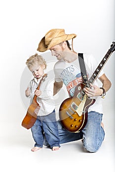 Father is playing with his son on guitars