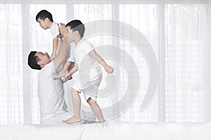 Father playing with his sons in the bedroom