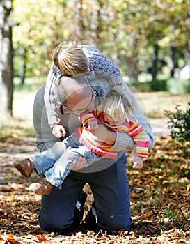 Father playing with kids in autumn park photo