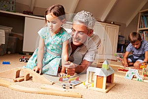 Father playing with kids and toys in an attic playroom