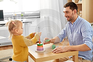 Father playing with little baby daughter at home