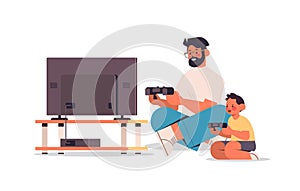 father playing video games with little son parenting fatherhood concept dad spending time with his kid