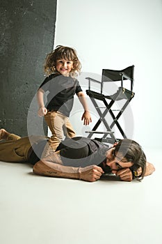 Father playing with young son in their sitting room