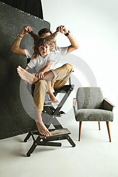 Father playing with young son in their sitting room