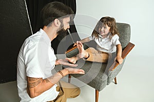 Father playing with young son in their sitting room