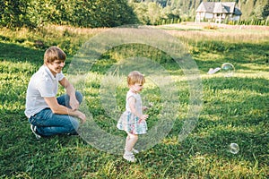 Father plays with his daughter with soapbubble