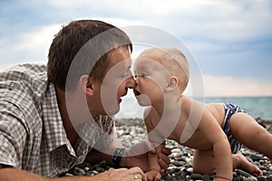 Father plays with son on a beach