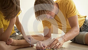 Father plays with son. The family spends time together. Robotics classes at home with parents.