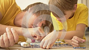 Father plays with son. The family spends time together. Robotics classes at home with parents.