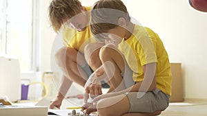 Father plays with son. The family spends time together. Robotics classes at home with parents.