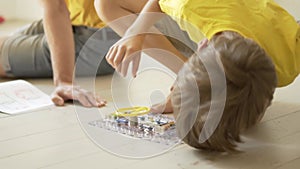 Father plays with son. The family spends time together. Robotics classes at home with parents.